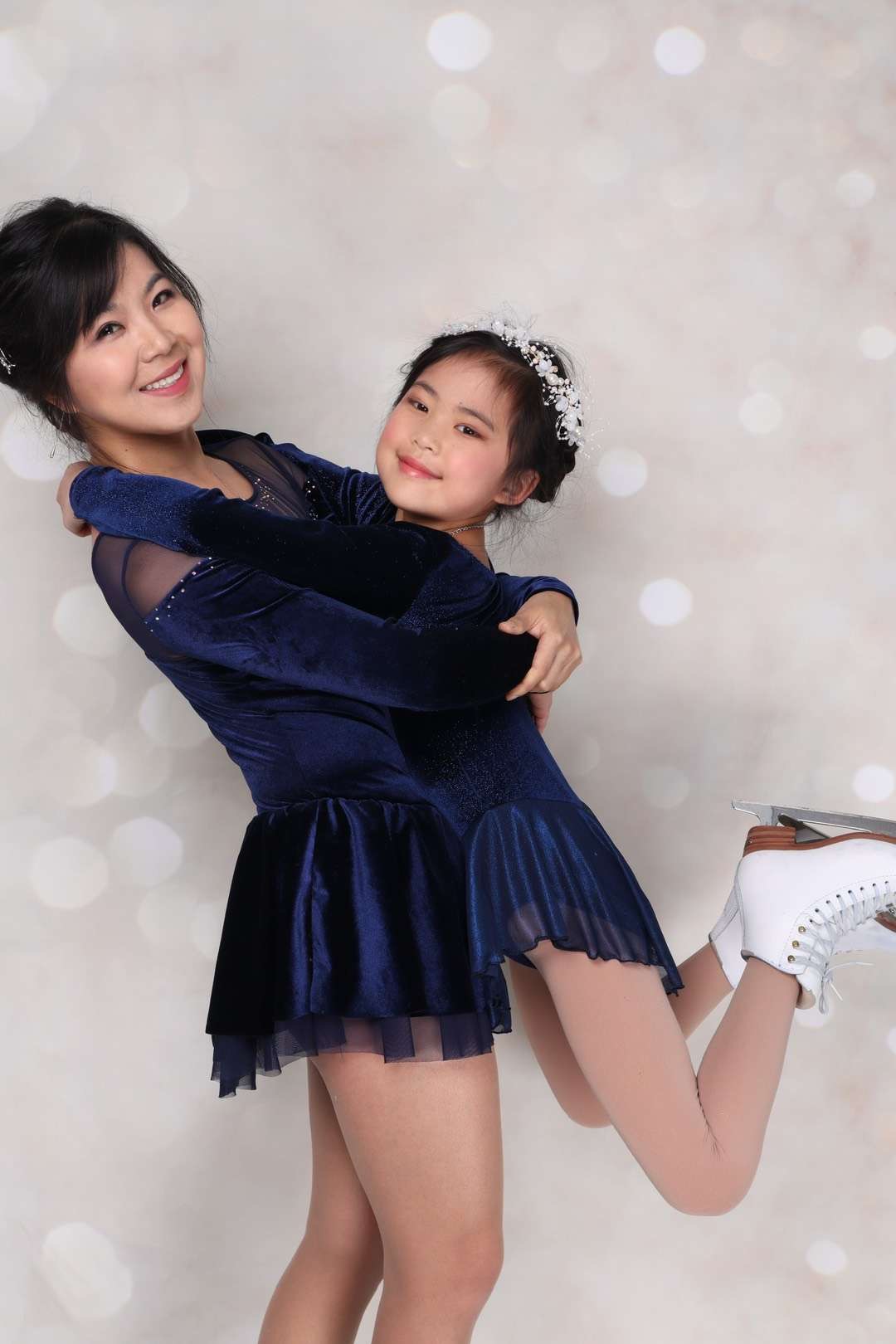 Dressed in purple  skating dresses, mother Ashley Chen and daughter Melody Hui embrace.