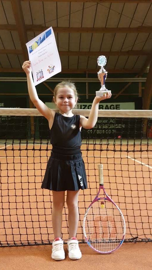 A young Von Felten displays the hardware she won at a tennis tournament.