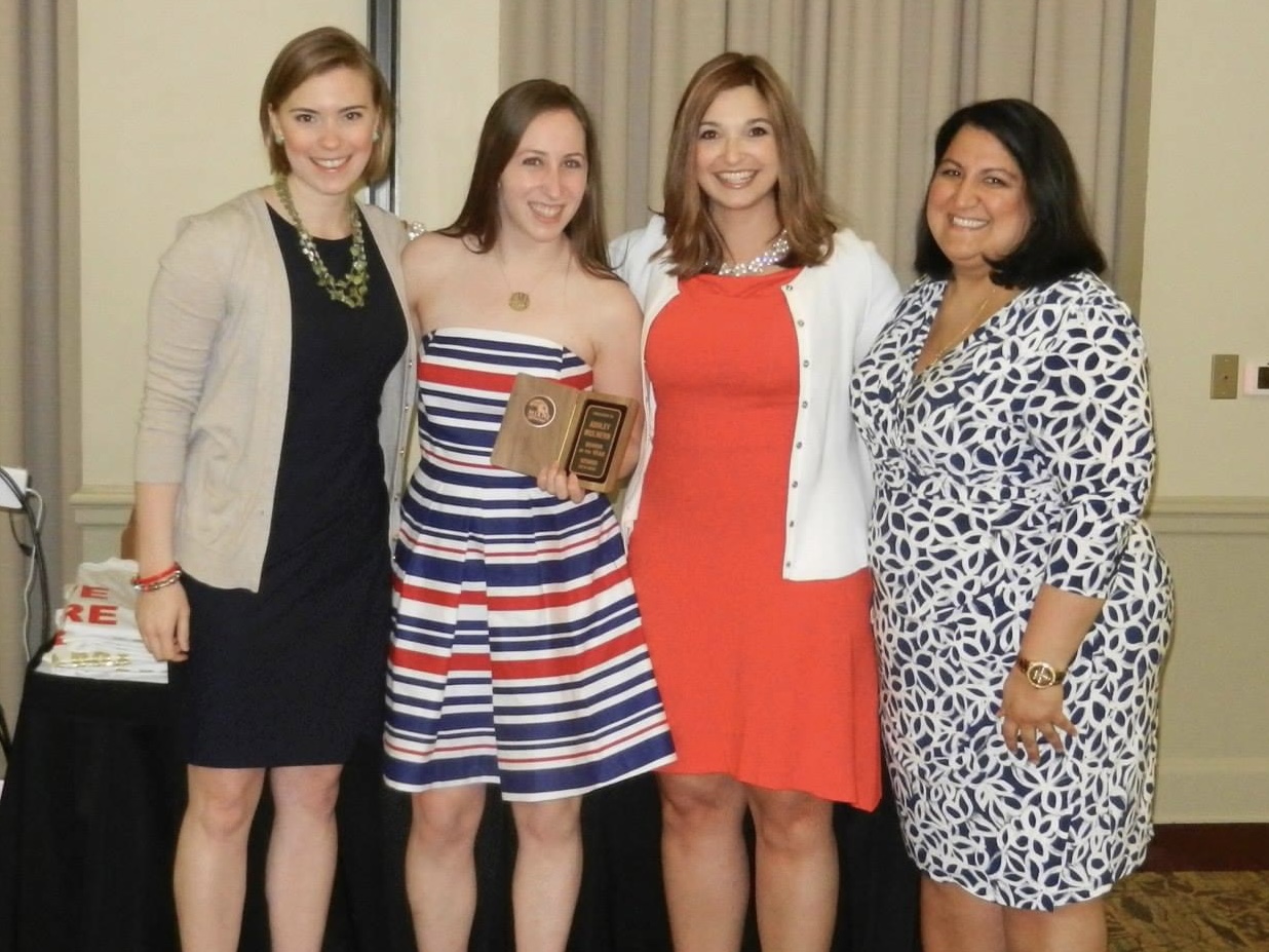 Ashley Mulhern (second from left in a striped dress) receives the senior of the year award from Katie Bowling, left, DeGirolamo and Shoker.