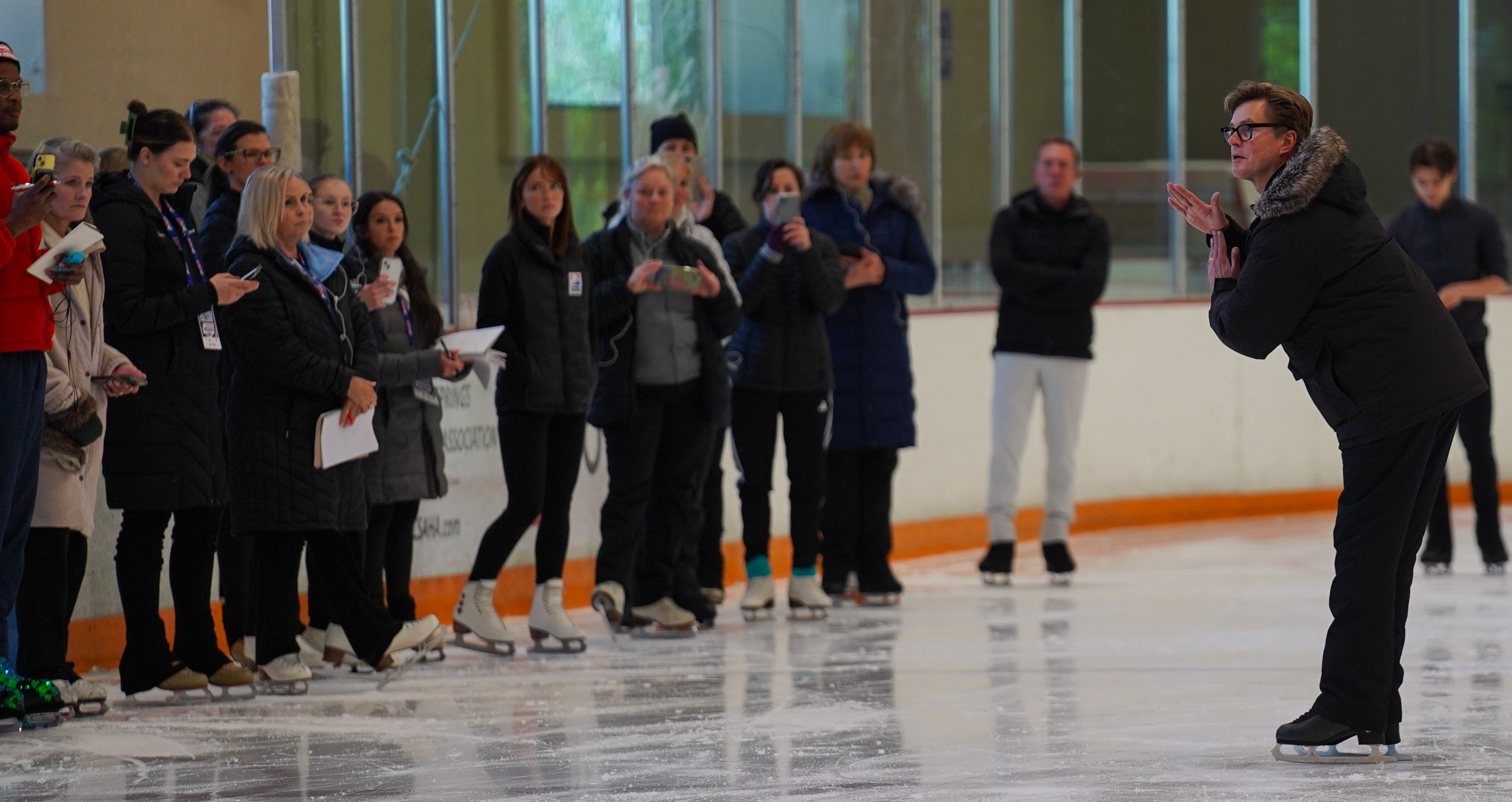 Faculty facilitators Peter Johansson and Jeff DiGregorio deliver a talk on the ice about Lutz and flip edge take-offs with the coaches.