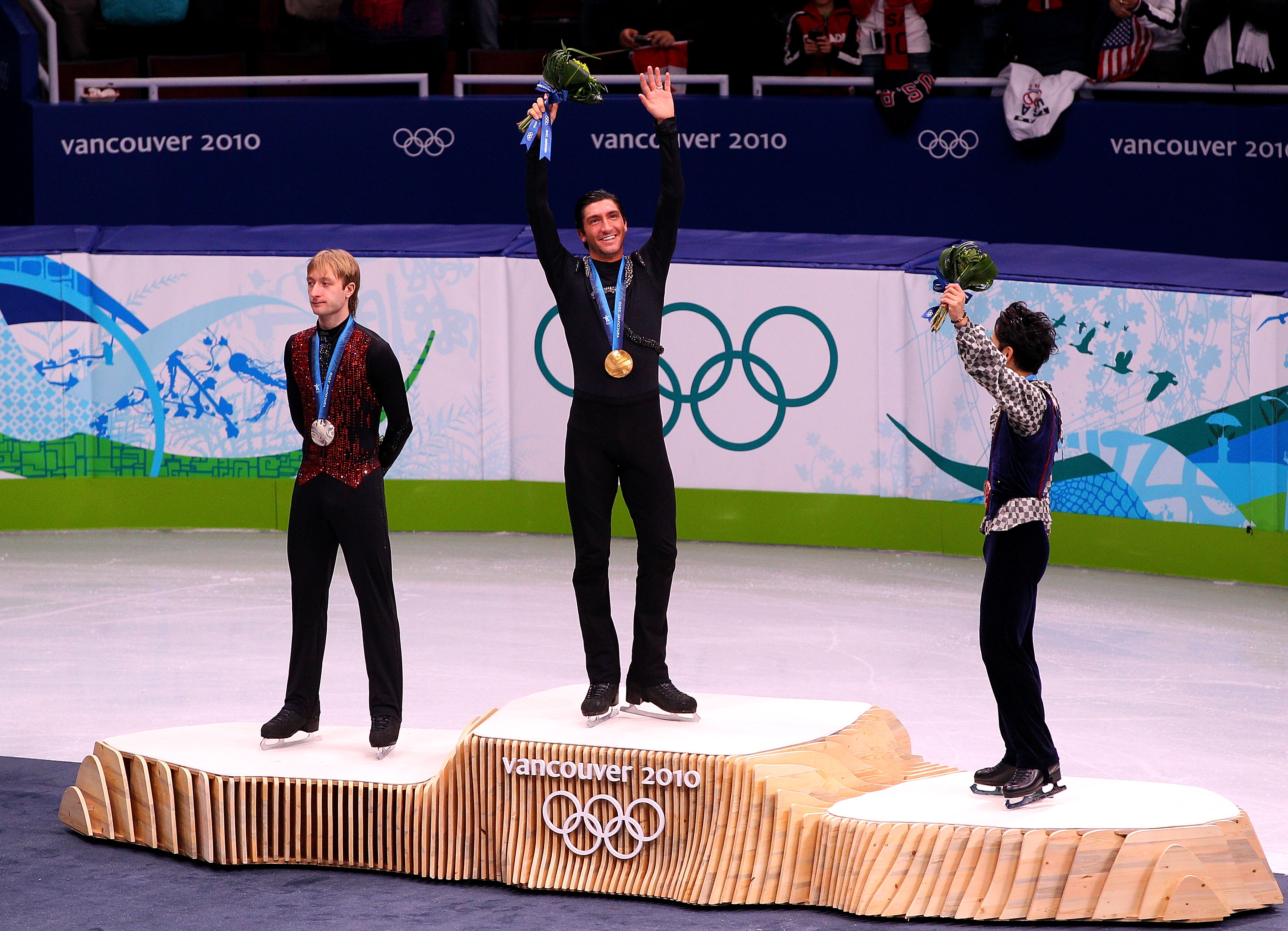Evan Lysacek and Evgeni Plushenko atop the podium in the middle of the ice.