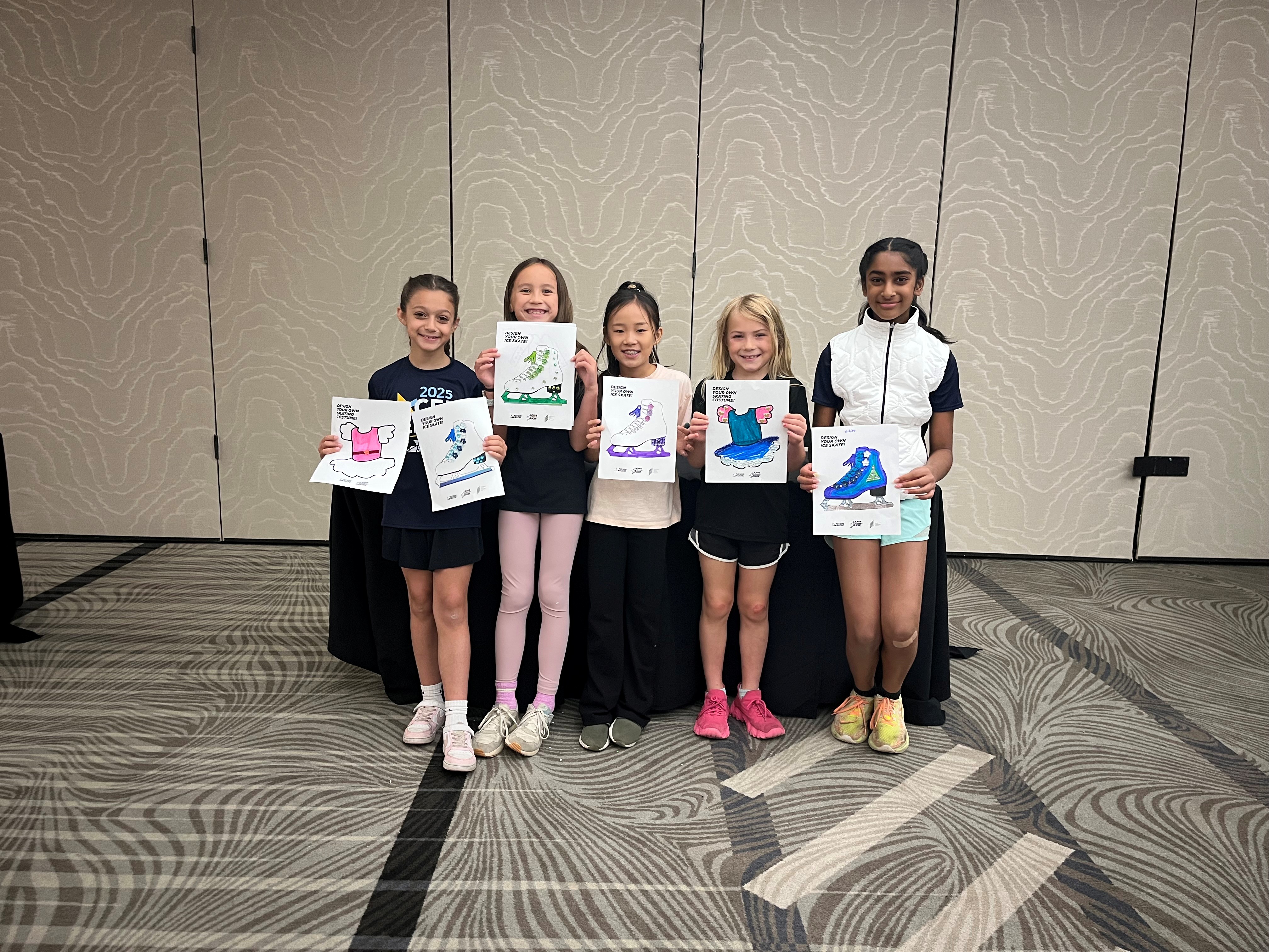 A group of skaters hold up some of their artwork from the Excel Final and Festival