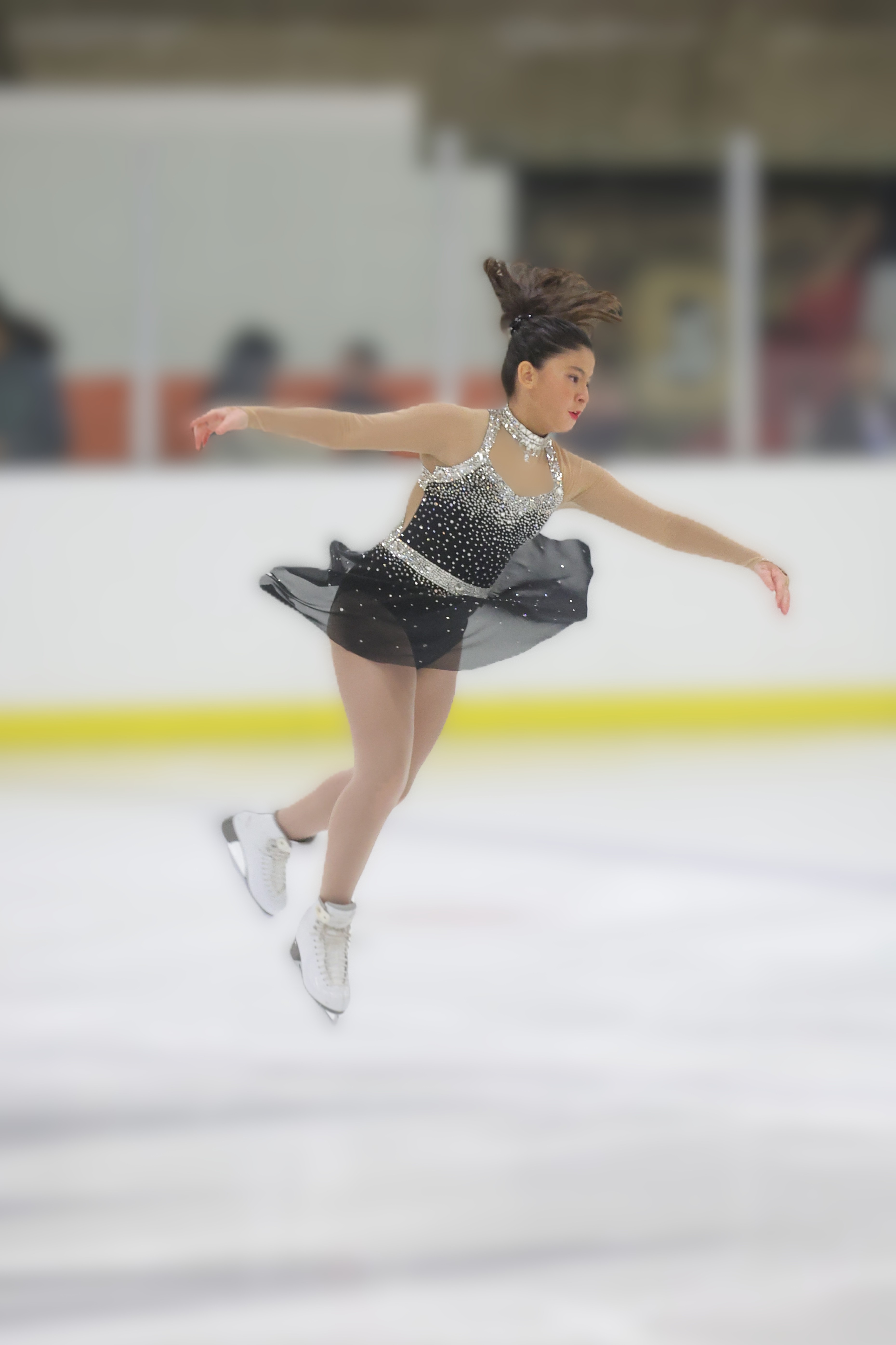 Ashley Gonzalez, wearing a dark gray costume, files through the air at a regional competition.