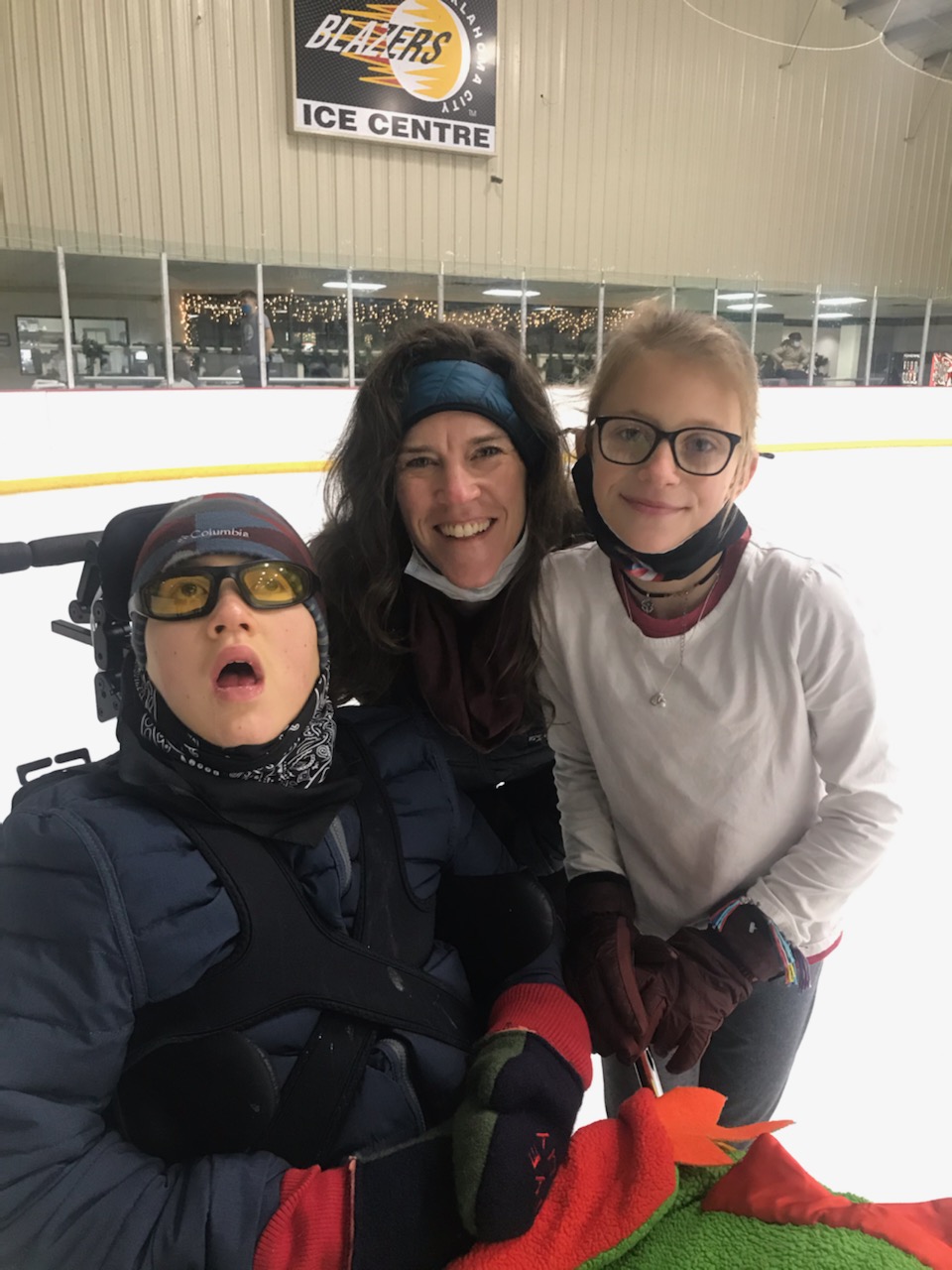 Rye poses for a photo on the ice with his mom and sister.