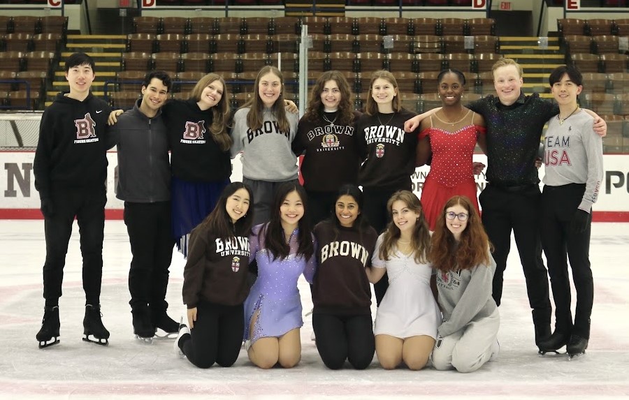 Daniel King, standing second row, far left, wearing a black Brown University sweatshirt and black pants with several of his Brown Figure Skating teammates