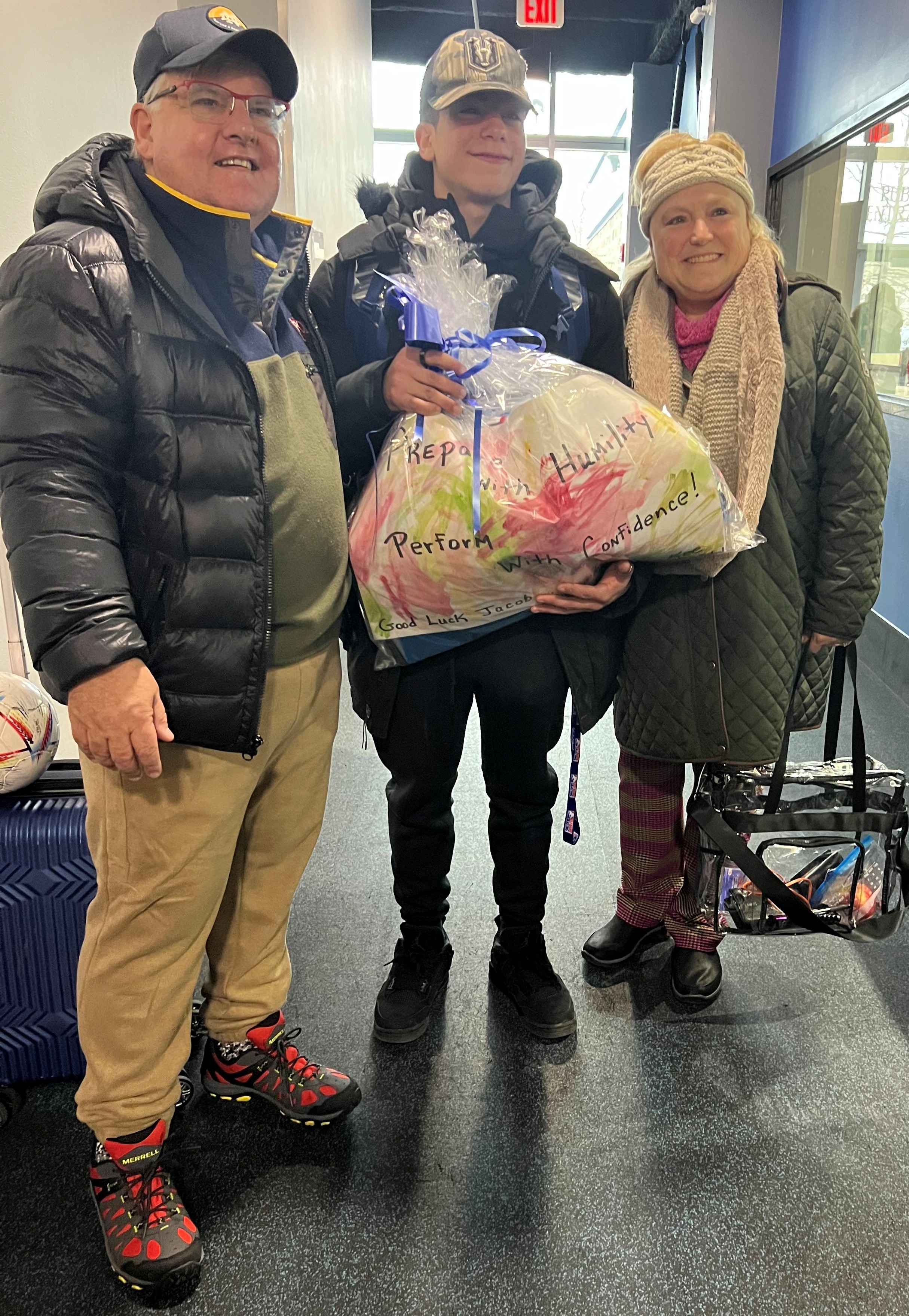 Scott Jarrett, left, gives Jacob Sanchez and his mother a gift package from his classroom.