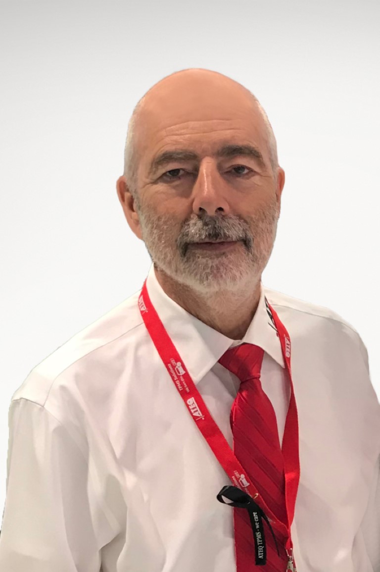 Jacques Mouchet headshot. Mouchet is an older man wearing a white collared shirt and red tie with a red lanyard