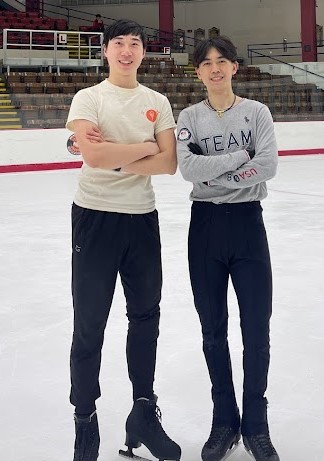 Daniel King, left, in a white shirt with a small red circle, and Vincent Zhou, wearing a gray T-shirt, have their arms folded for a photograph.