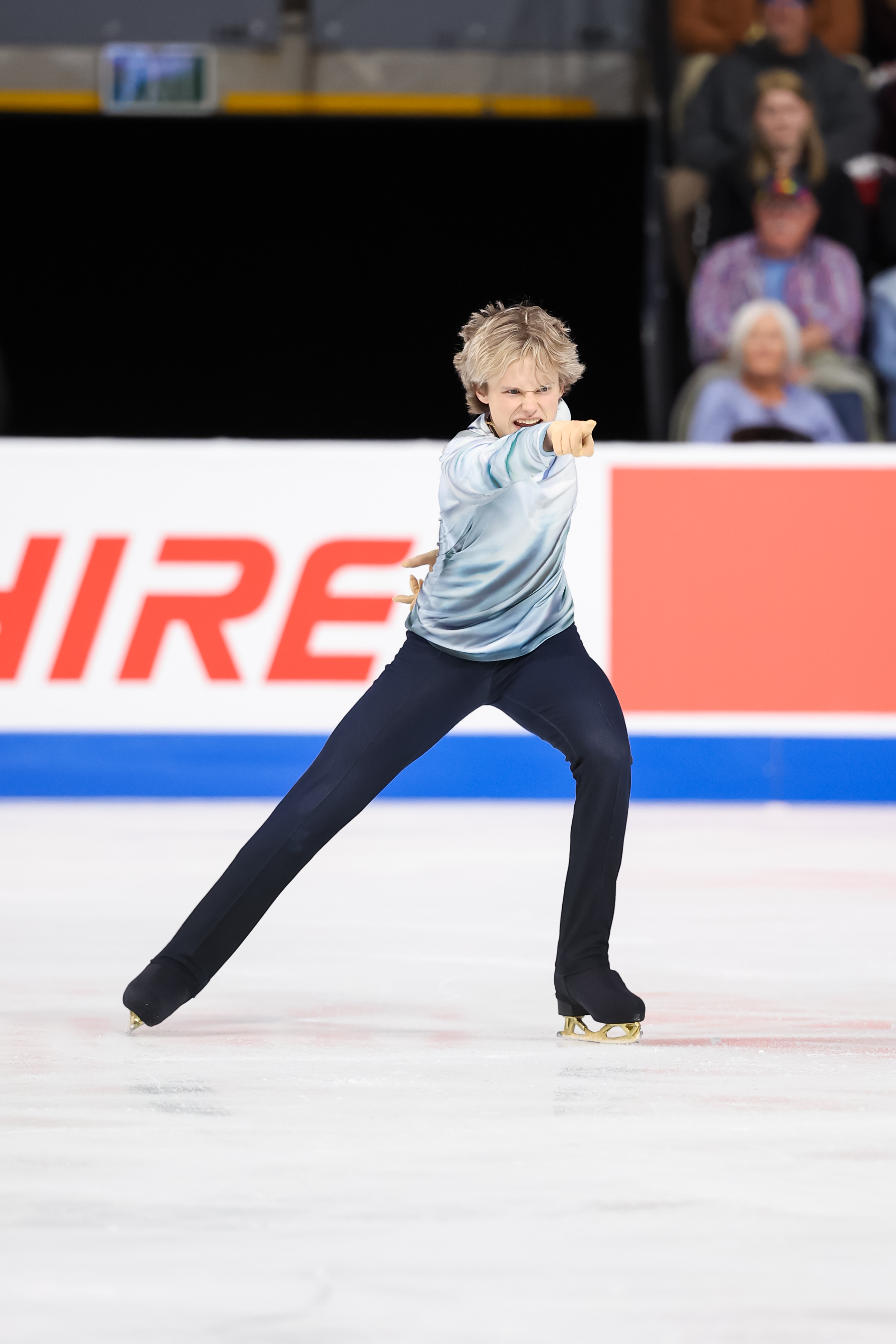 Dressed in a gray top and black pants, Ilia Malinin points ahead during a performance this fall.
