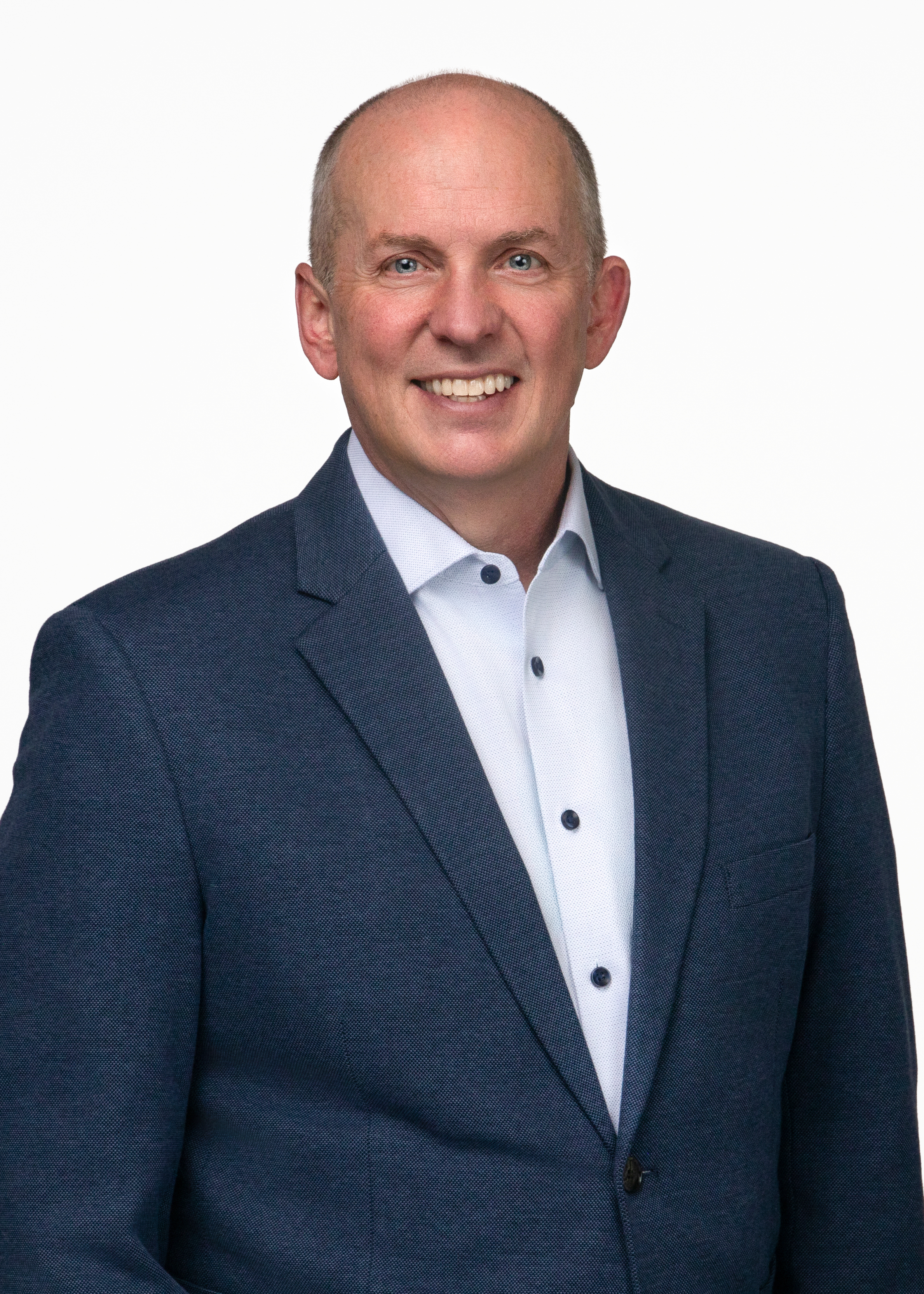 Headshot of Matt Farrell. Matt is an older white man wearing a white button down shirt with a navy blue blazer on top.