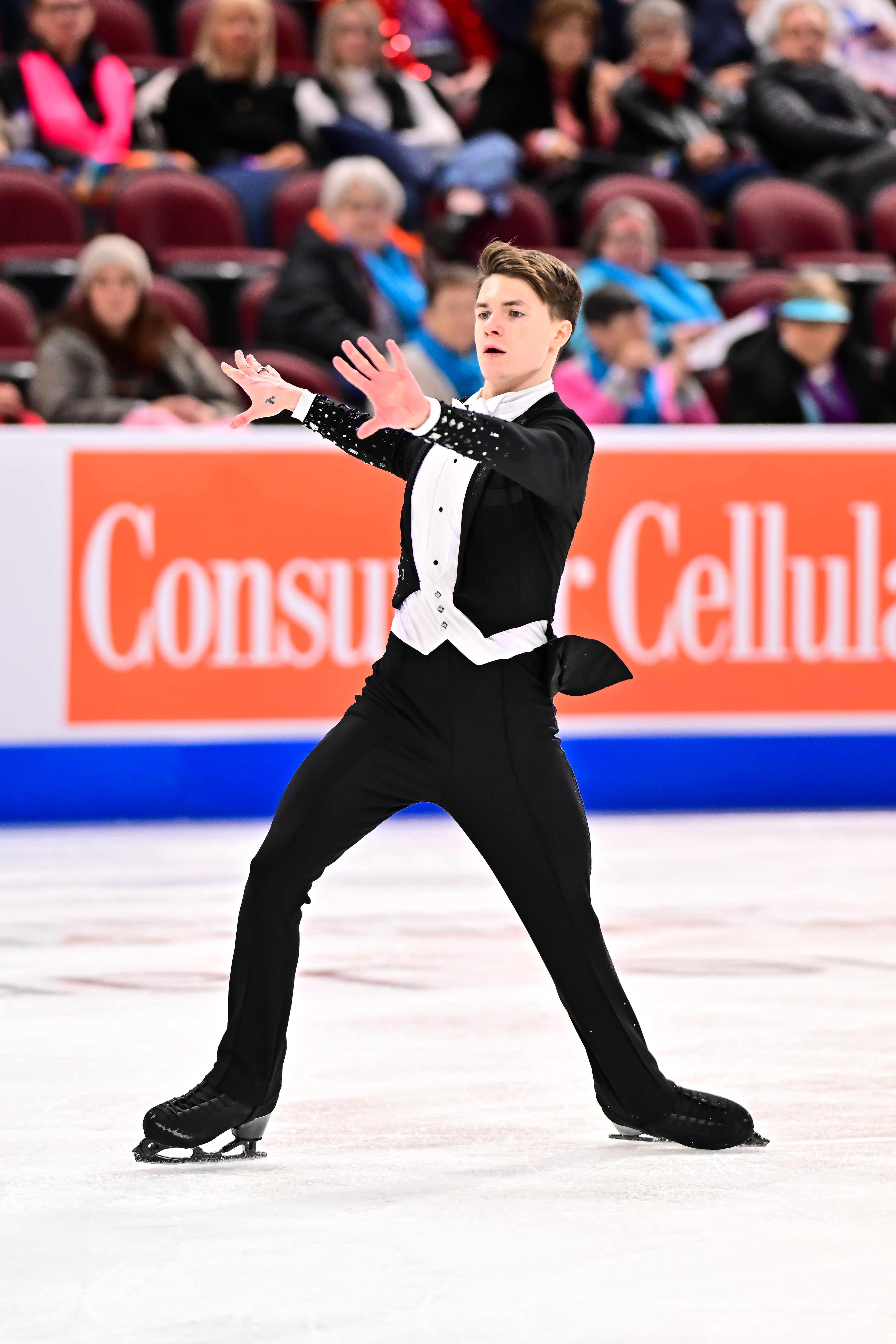 Wearing a black tuxedo and white shirt, Max Naumov performs his short program at the 2025 U.S. Championships.