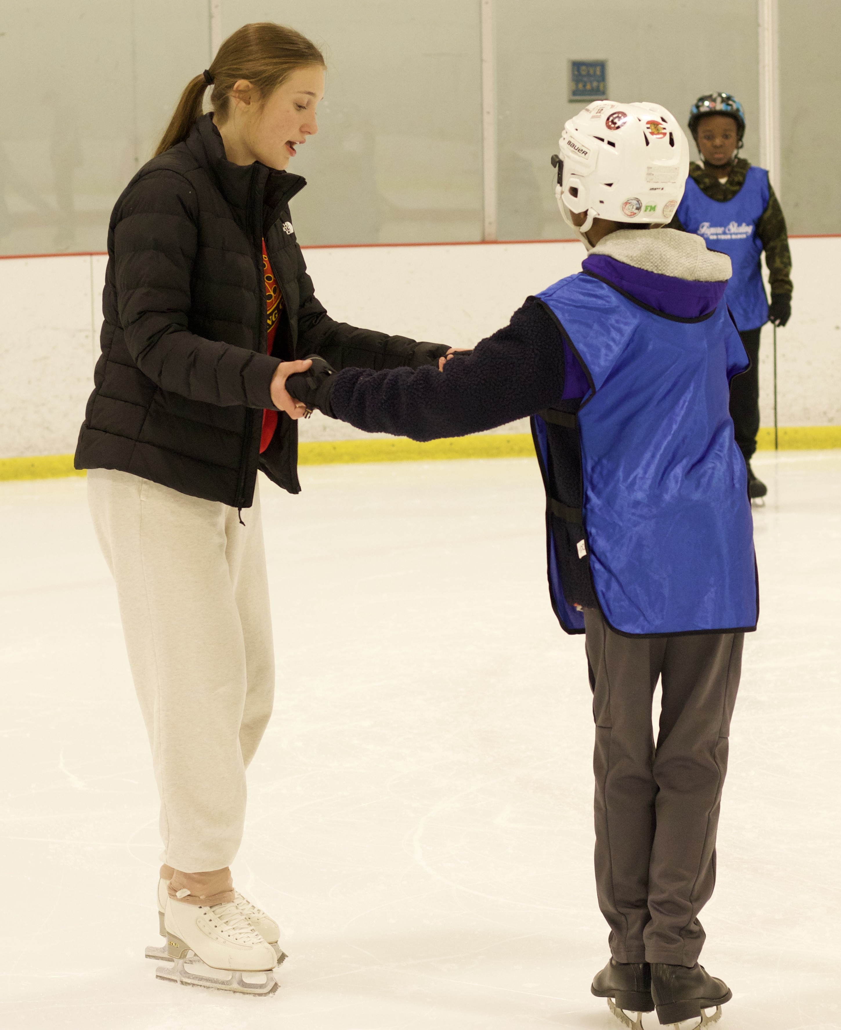 Volunteer coach Jordyn Bever gives a skater individualized instruction.