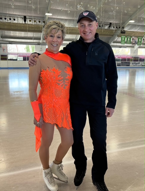 Sharon Rzaza and her coach Igor Igor Yaroshenko, both dressed in red, standing on the ice