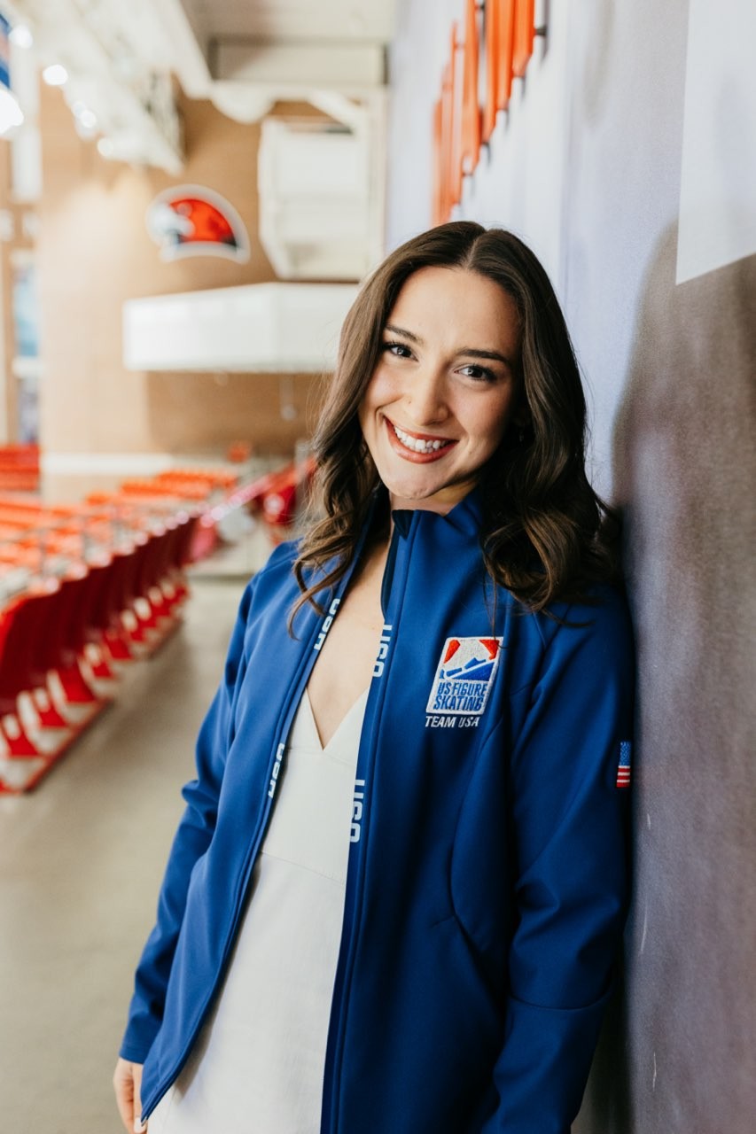 Wearing a blue U.S. National Team jacket, Sammie Levine stands proud inside Goggin Ice Arena.