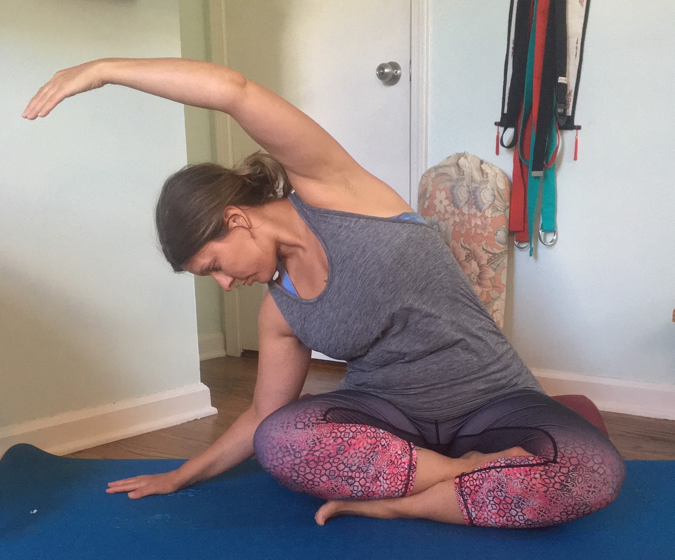 Sarah Neal practices yoga while sitting in her home.