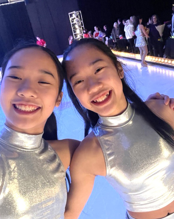 Sophia Hu and Olivia Hu, wearing all white costumes, share a selfie.