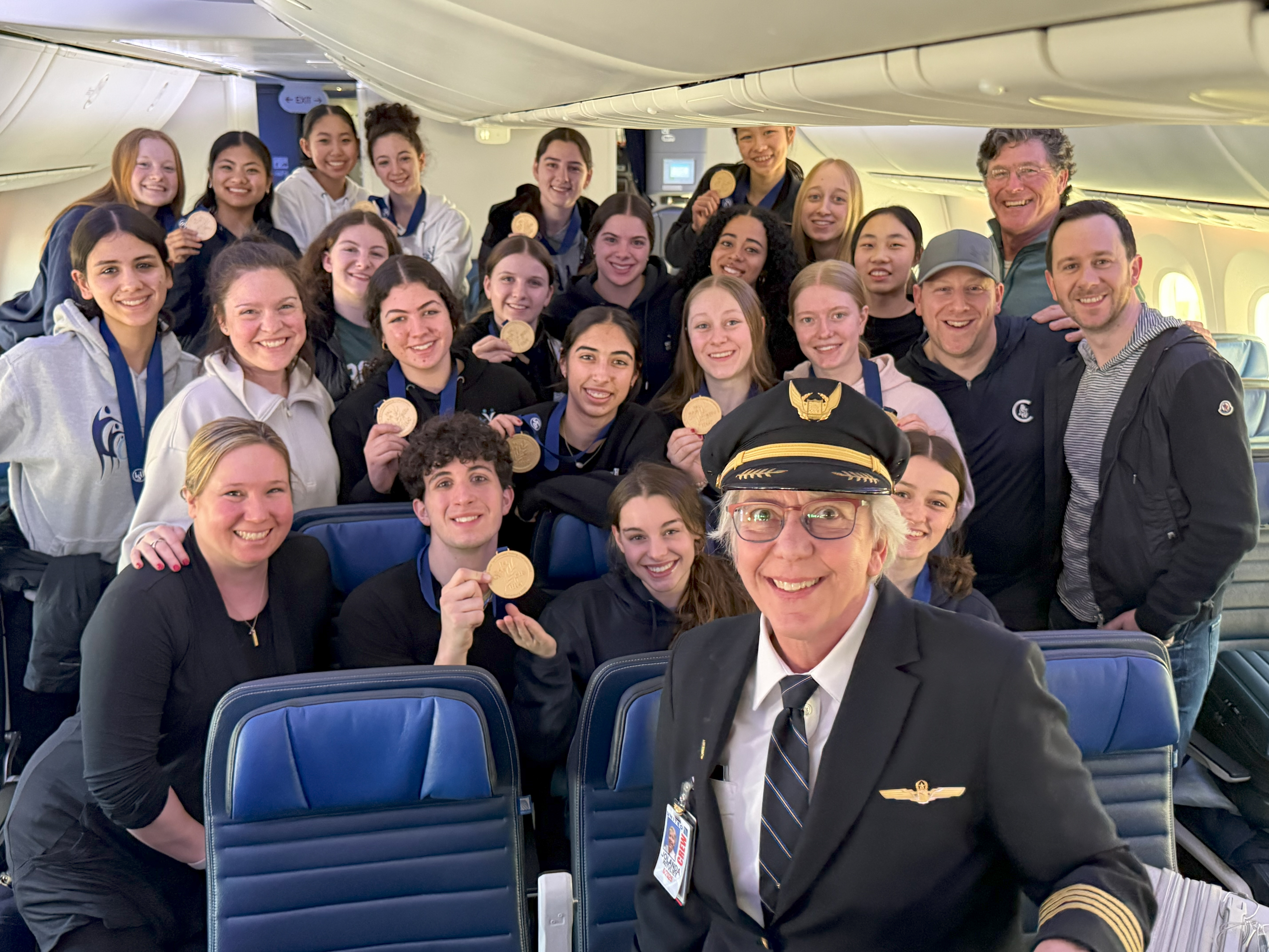 Teams Elite grabs a photo with their pilot upon returning home from the World Championships.