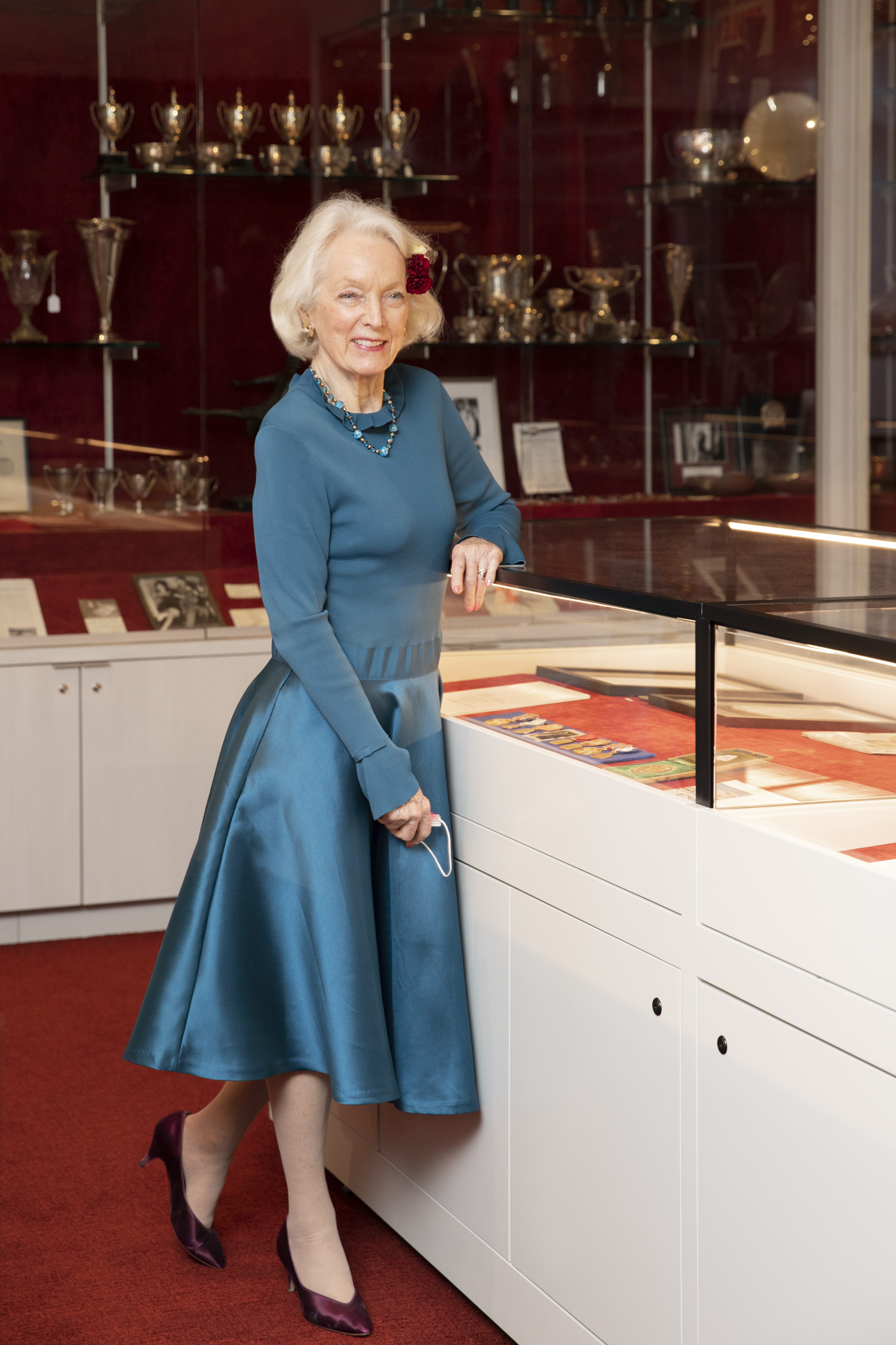 Tenley Albright with short white hair in a classic style teal dress.