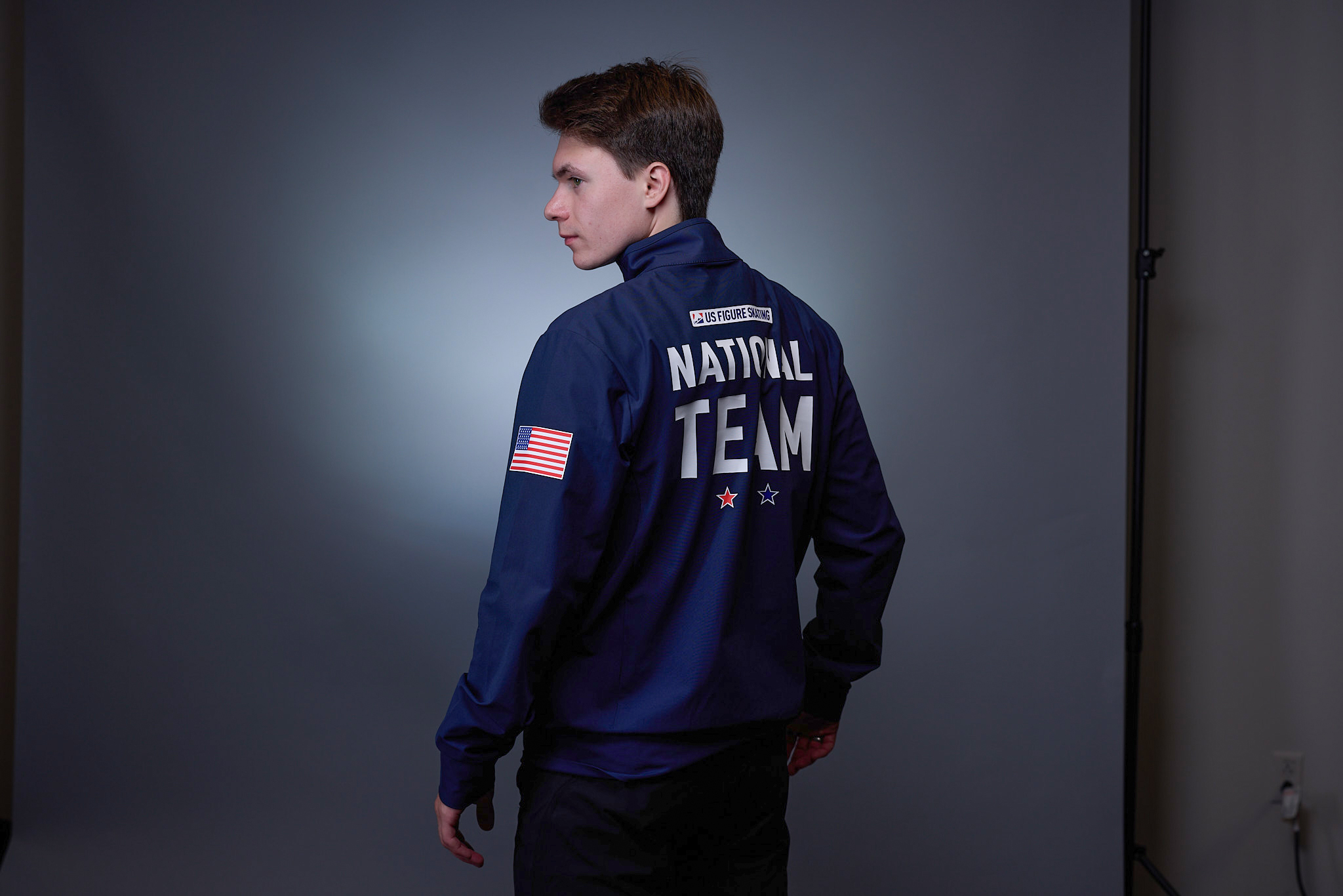 Max Naumov dons his blue U.S. National Team Jacket, with back turned to camera.
