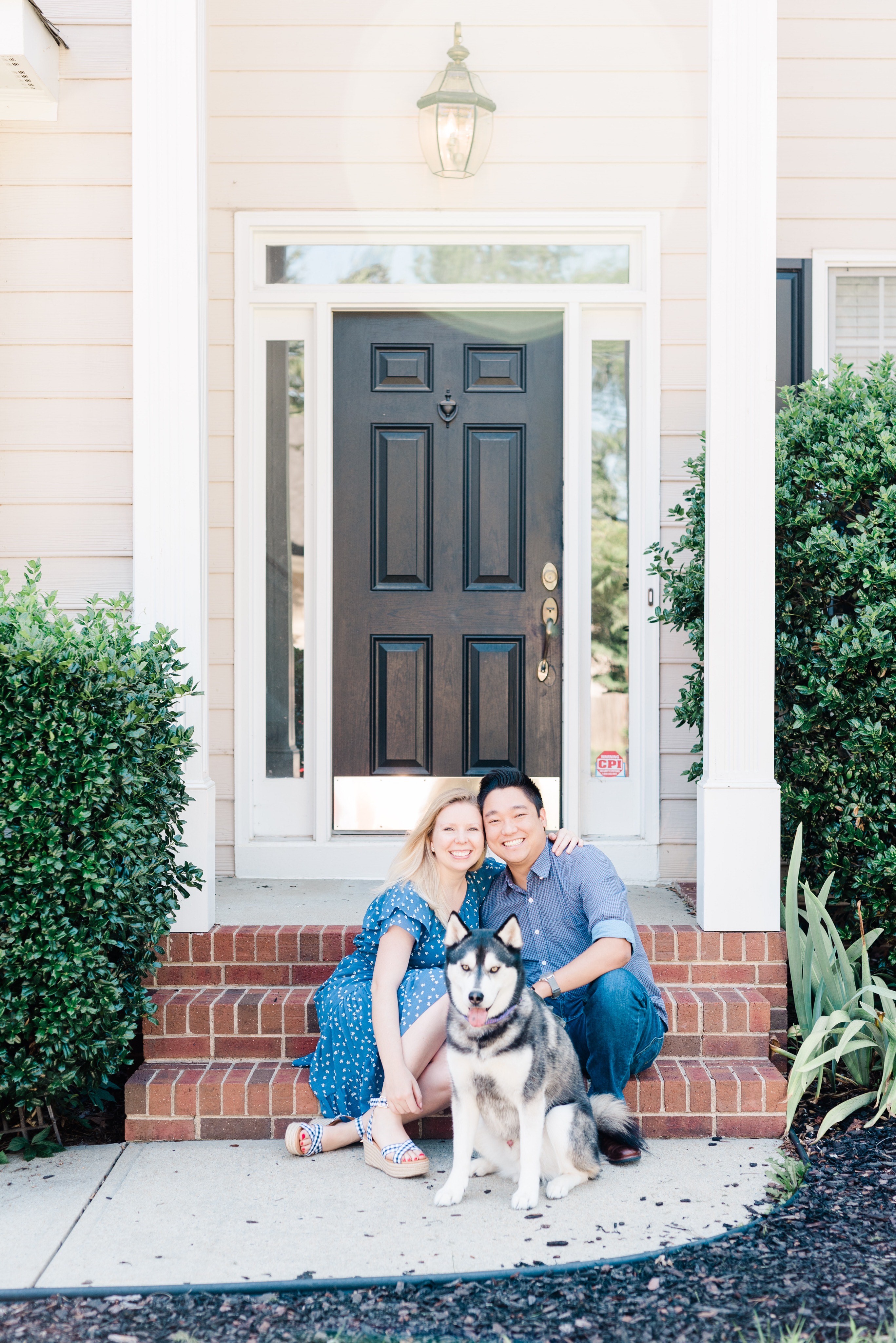 Rachael Flatt sits on the steps of their house with husband Eric ad their dog Jax