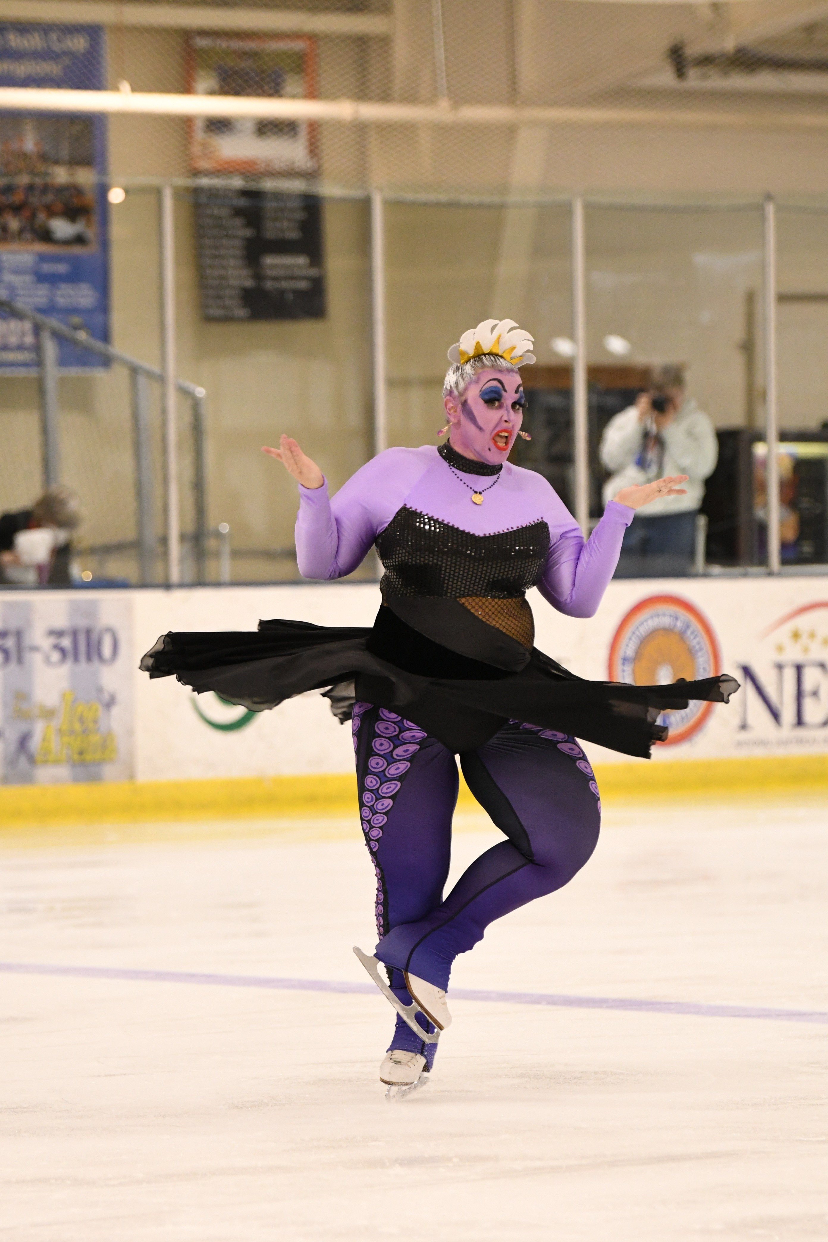 Rebecca Yowler mid-one-foot-spin while wearing a black and purple Ursula costume.