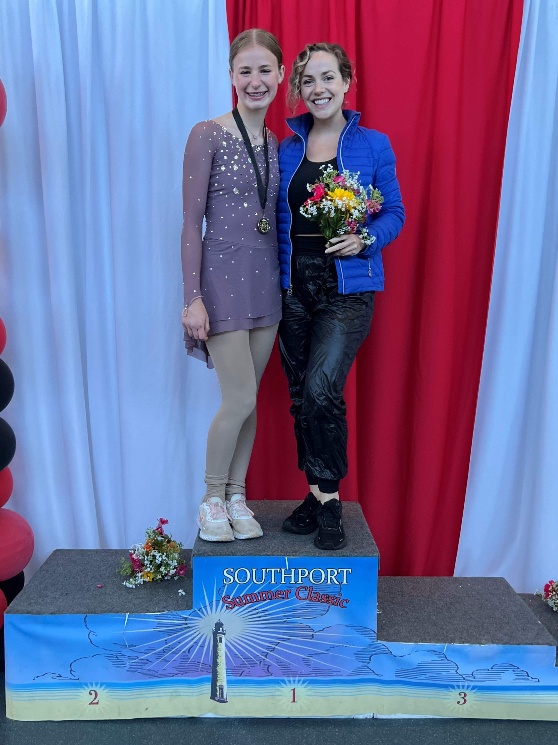 Madeline Stammen (right) now coaches at Ghost Pirates in Savannah, Georgia. She stands on the podium with one of her skaters at the Southport Summer Classic.