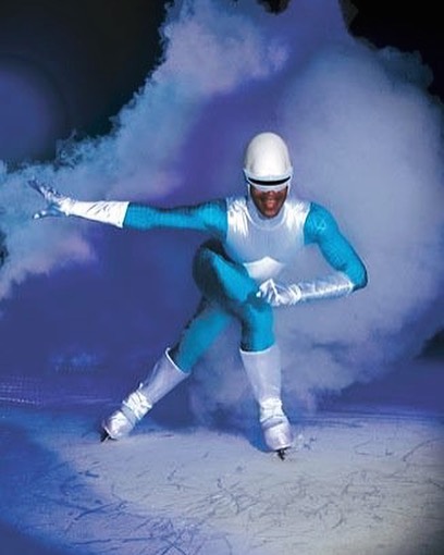 Skyler leans forward wearing a blue and white superhero costume to act as Frozone from The Incredibles for Disney on Ice