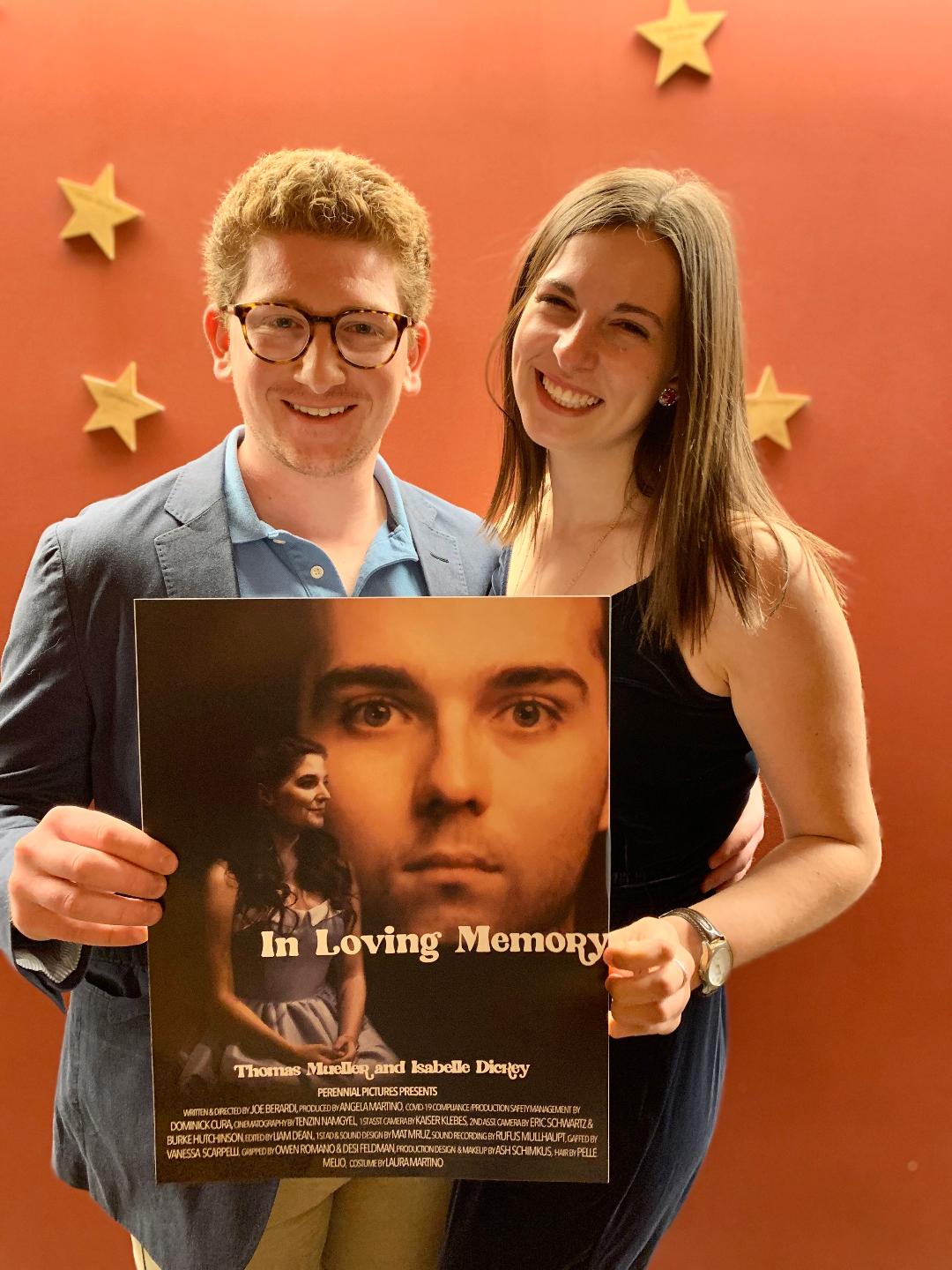 Angela Martino and her partner hold up a movie poster.