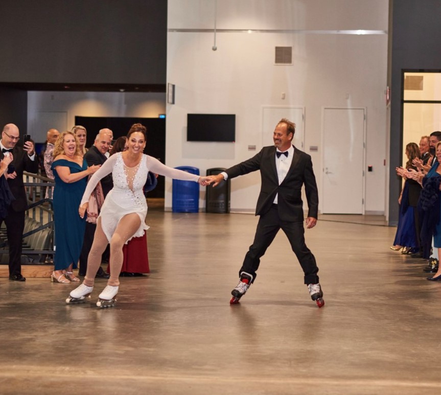Donna and Kevin enter their reception on roller skates. Donna is wearing a long sleeve skating costume and Kevin has on a black suit with a black bow tie