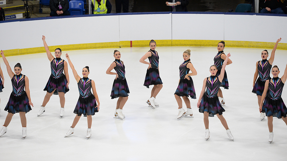 Collegiate synchronized skating team performs at a competition