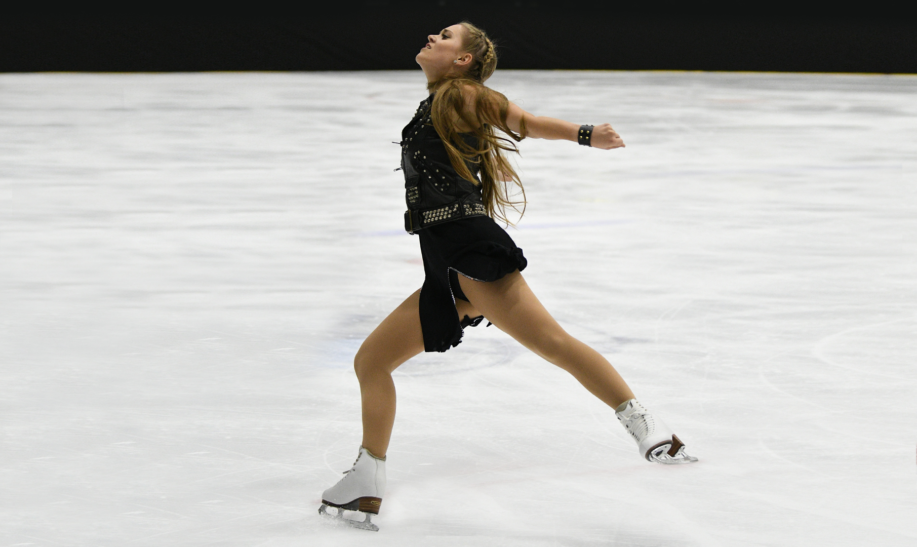 Solo dance skater performs in front of a crowd.