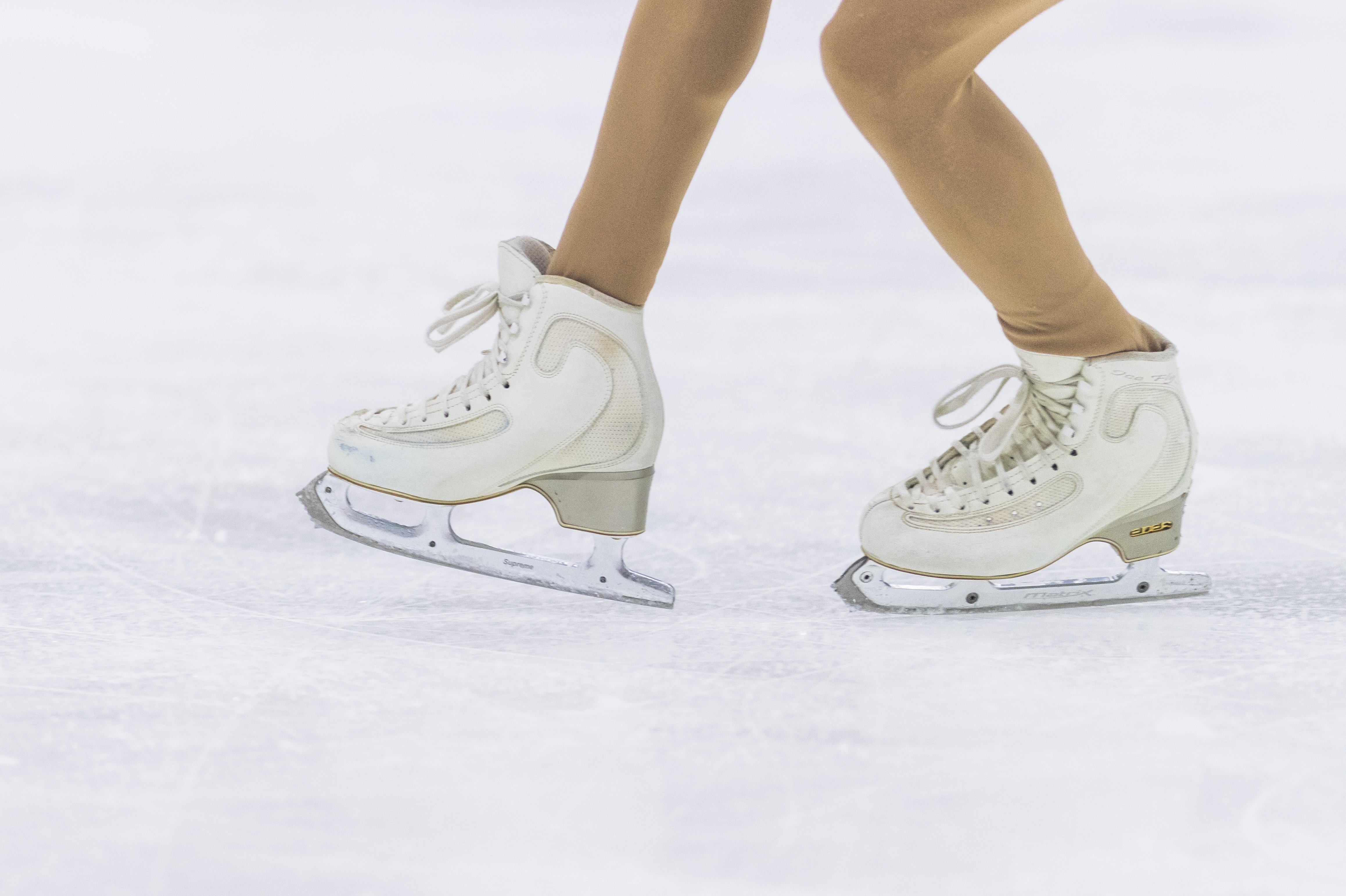 close up of the ice skates of a figure skater