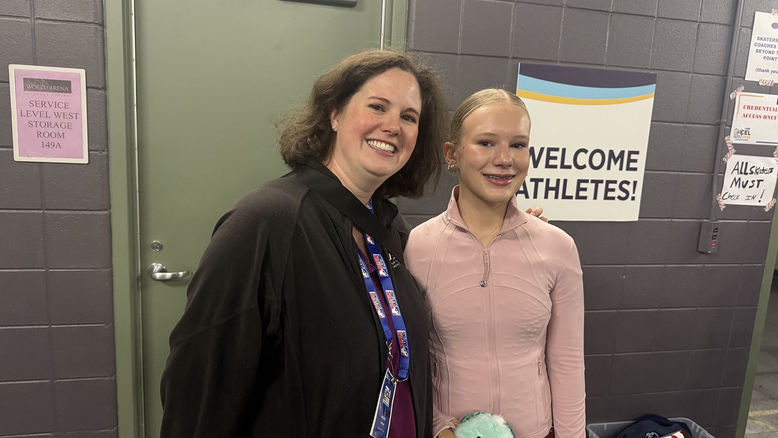 Coach Jessica Stratton, dressed in black, stands backstage with student Charlotte Anderson, dressed in a peach-colored costume.
