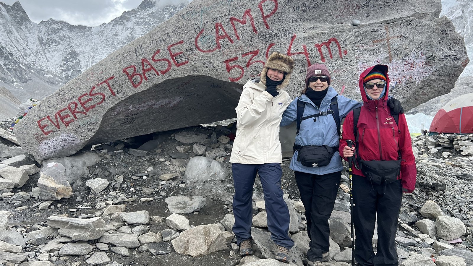 Alysa Liu, dressed in a white winter coat and cap, stands with friends at Mt. Everest Base Camp.