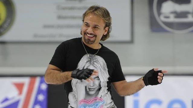 Photo of Jose. He is a Hispanic man with shoulder length blonde hair. He is wearing a black tshirt and black fingerless gloves 