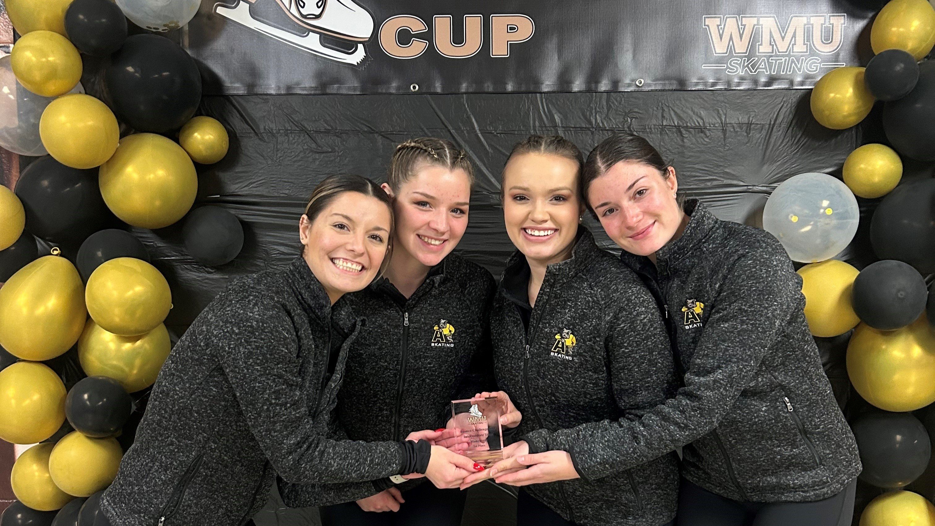 Members of the Adrian College Figure Skating Team pose with their trophy. 