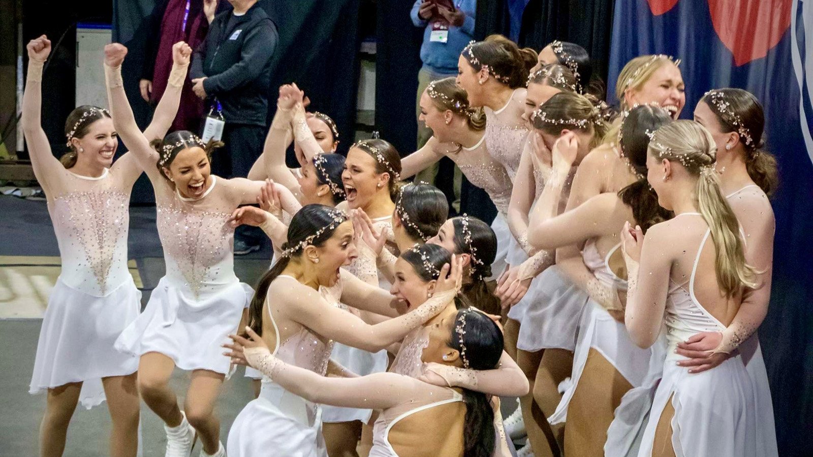 Miami University, wearing white dresses, celebrate in the kiss and cry