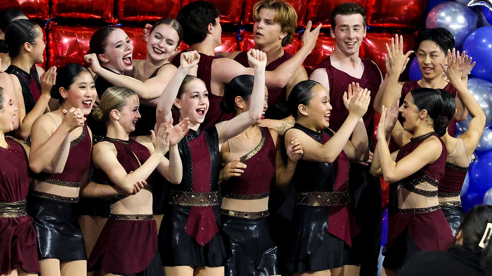 Sophie Joline von Felten, front row, arms extended up, celebrates Act 1 of Boston's victory at National Showcase.