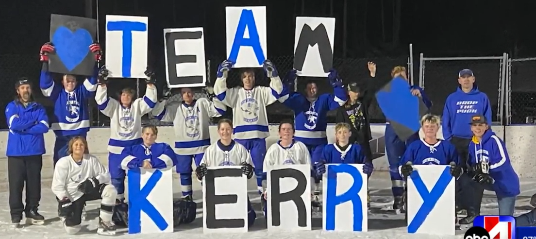 A local hockey team pays tribute to the late Kerry Jo Fain by holding up letter spelling out "TEAM KERRY" 