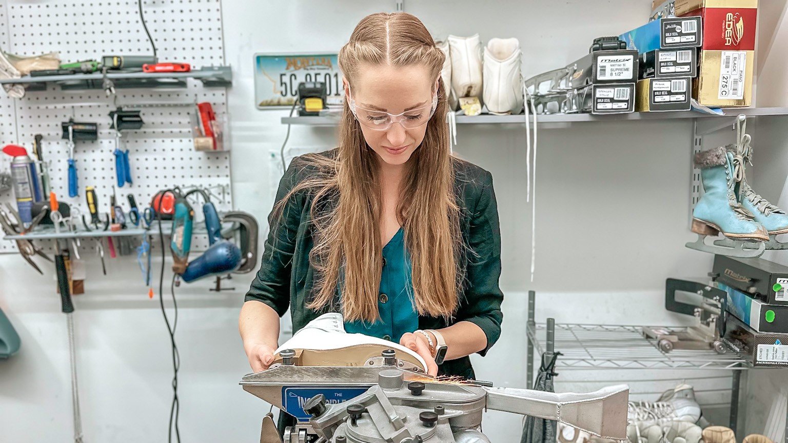 Aislinn Munck-Owen, wearing a green top, places blades on a boot.