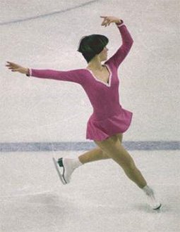 Dorothy Hammill, wearing a pink dress and white skates, performs a step sequence at the 1976 Olympic Winter Games.