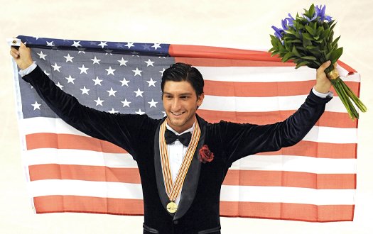 Evan Lysaeck holds a flag behind his head with flowers in his hand.