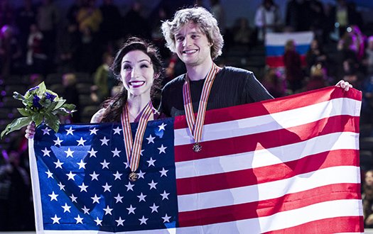 Meryl Davis and Charlie White pose with their medals and a flag at Worlds.