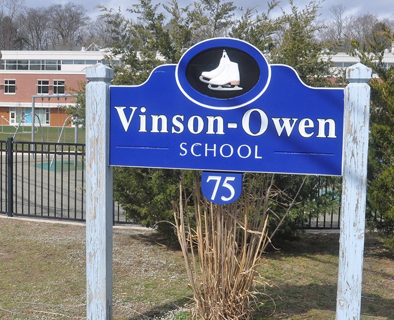 The Vinson-Owen School sign is blue and features a pair of ice skates.