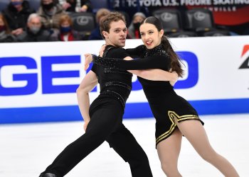 Caroline Green and Michael Parsons skating during their rhythm dance in black costumes.