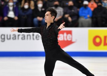 Camden Pulkinen skates in an all-black costume with his arm out in front.