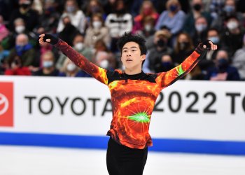 Nathan Chen in an orange and black galaxy shirt while skating his free skate at the 2022 Toyota U.S. Figure Skating Championships. 