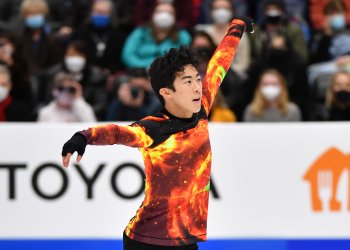 Nathan Chen in an orange and black galaxy shirt while skating his free skate at the 2022 Toyota U.S. Figure Skating Championships. 