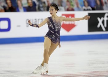 Alysa Liu wears a purple dress as she lines up for a jump at the U.S. Championships.