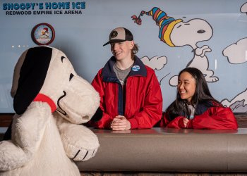Snoopy talks to the office staff, dressed in red jackets, at Snoopy's Home Ice.
